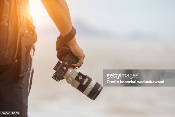 photographer is holding a camera - digitale spiegelreflexcamera stockfoto's en -beelden