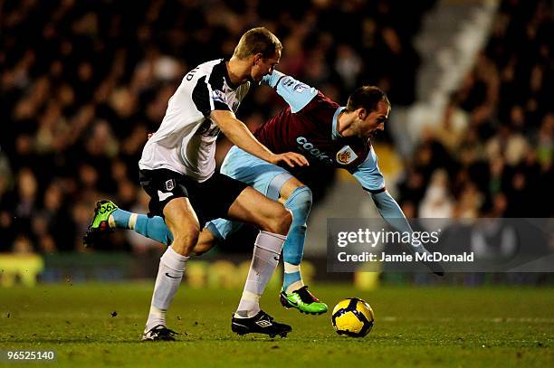 Brede Hangeland of Fulham tackles Steven Fletcher of Burnley during the Barclays Premier League match between Fulham and Burnley at Craven Cottage on...