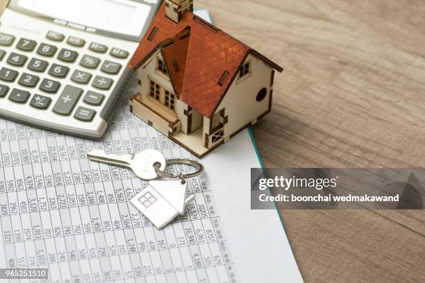 house resting on calculator concept for mortgage calculator, home finances or saving for a house - housing loan stock-fotos und bilder