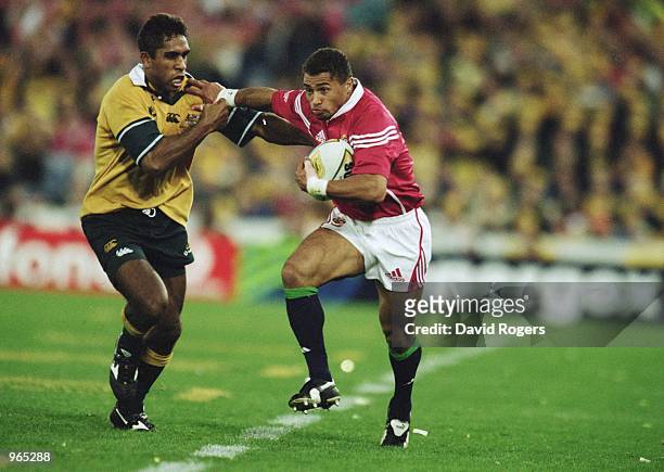 Jason Robinson of the Lions hands off Andrew Walker of Australia during the Second Test Match between the Australian Wallabies and the British and...