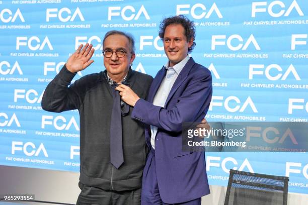 John Elkann, chairman of Fiat Chrysler Automobiles NV, right, holds a tie in front of Sergio Marchionne, chief executive officer of Fiat Chrysler...