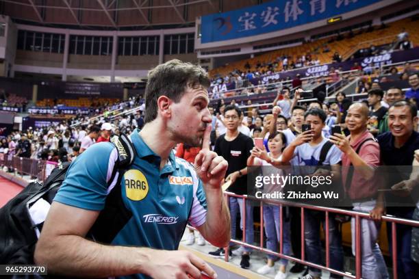 Timo Boll of Germany signs for the crowd after the men's singles match Round of 16 compete with Liang Jingkun of China during the 2018 ITTF World...