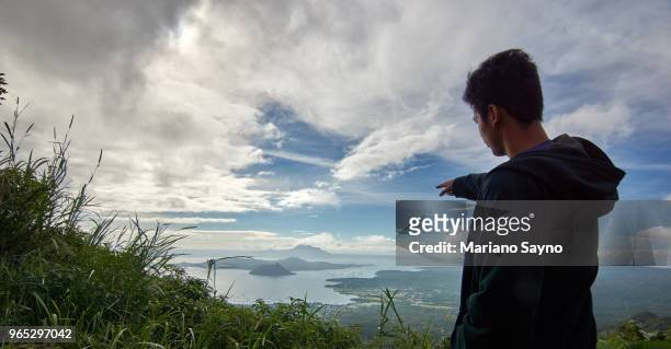 man pointing in top of a mountain - tagaytay stock pictures, royalty-free photos & images