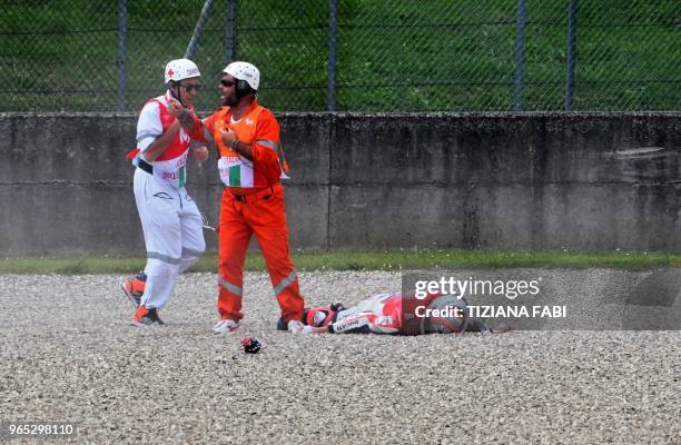 Medical staff stand by lying Ducati Team's italian rider Michele Pirro after a crash during a free practice session ahead of the Italian MotoGP Grand...