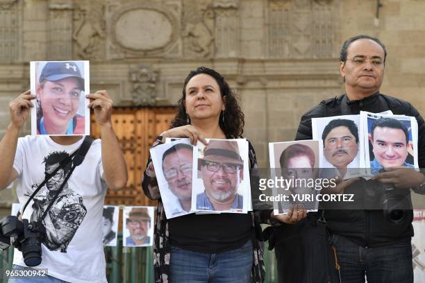 Members of the press hold images of colleagues during a protest against the murder or disappearance of more than 140 journalists and photojournalists...