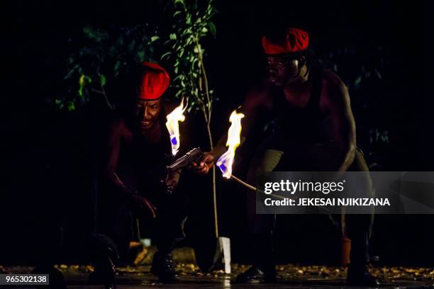 Actors play two red berret soldiers with open flame torches searching for innocent civilians who have deserted their homes hiding in the thick bush...