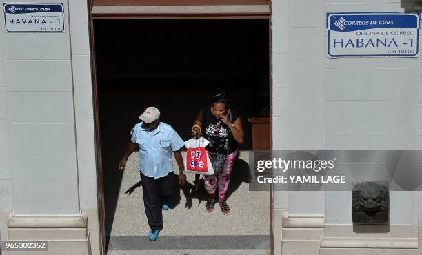 Cubans walks out of a post office in Havana after direct mail between Cuba and the United States was re-established, on June 1, 2018. - Direct mail...