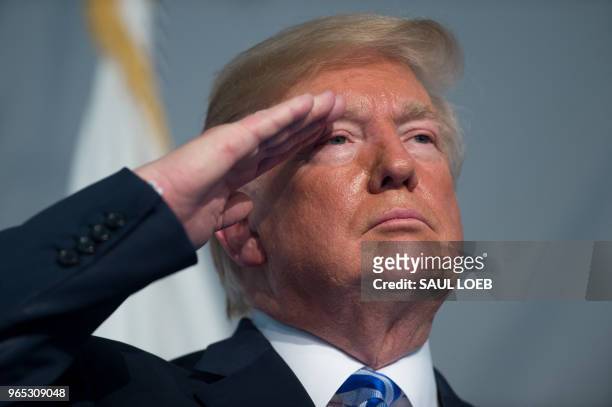 President Donald Trump salutes during a Change of Command ceremony as Admiral Karl Schultz takes over from Admiral Paul Zukunft as the Commandant of...