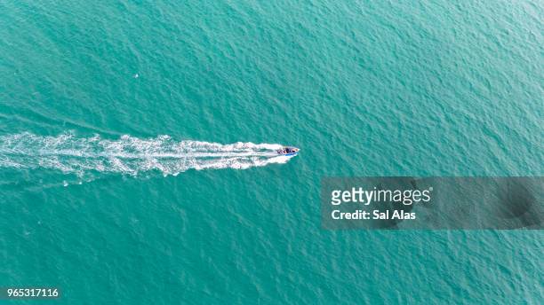 aerial view of fast travelling boat on an island - moreton island stockfoto's en -beelden