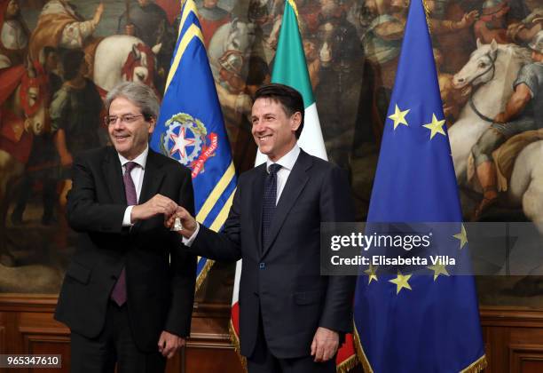 Italy's new Prime Minister Giuseppe Conte rings the bell which he received from outgoing Prime Minister Paolo Gentiloni marking the moment he takes...