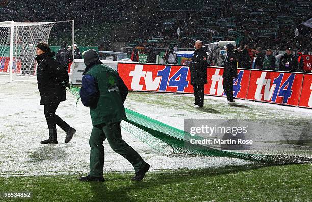 Greenkeepers cleaning the pitch from the snow prior to the DFB Cup quarter final match between SV Werder Bremen and 1899 Hoffenheim at Weser Stadium...