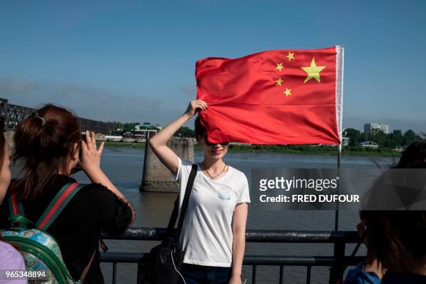 Chinese tourists take pictures from the 'Friendship Bridge' on the Yalu river in the Chinese border town of Dandong, in China's northeast Liaoning...