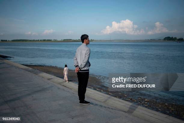 Chinese man stares at North Korea from the Chinese border town of Dandong, in China's northeast Liaoning province, on May 29, 2018. - The city of...