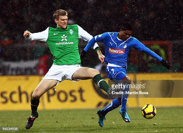 Per Mertesacker of Bremen and Maicousel of Hoffenheim battle for the ball during the DFB Cup quarter final match between SV Werder Bremen and 1899...