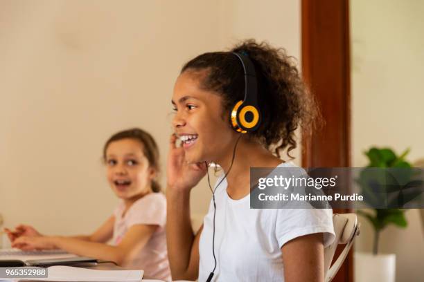 sisters doing homework at the kitchen table - オーストラレーシア ストックフォトと画像