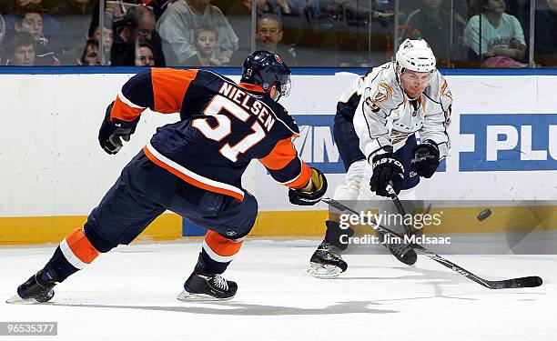 Alexander Sulzer of the Nashville Predators plays the puck against Frans Nielsen of the New York Islanders on February 9, 2010 at Nassau Coliseum in...