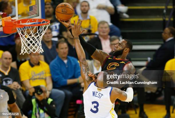 LeBron James of the Cleveland Cavaliers shoots against David West of the Golden State Warriors in Game 1 of the 2018 NBA Finals at ORACLE Arena on...