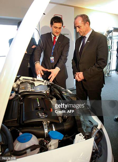 Spanish Minister of industry Miguel Sebastian gets some explanations at an exhibition about electric vehicles, during the second working session on...