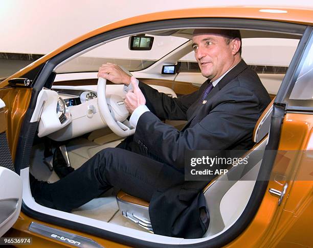 Spanish Minister of industry Miguel Sebastian sits in an electric car, as he attends an exhibition about electric vehicles, during the second working...