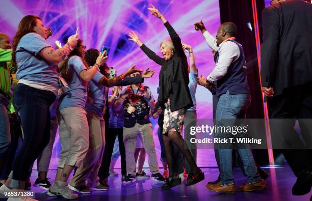 Alice Walton, daughter of Walmart founder Sam Walton, dances with Walmart associates onstage during the annual shareholders meeting event on June 1,...