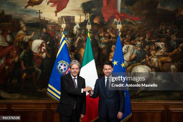 New Italian Prime Minister Giuseppe Conte receives a silver bell from former Prime Minister Paolo Gentiloni during the swearing-in ceremony at the...