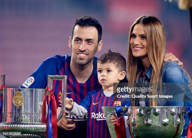 Sergio Busquets of Barcelona and his wife Elena Galera and his son Enzo Busquets pose with the trophy at the end of the La Liga match between...