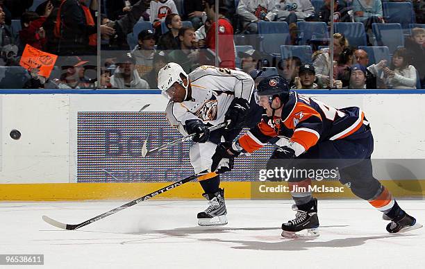 Joel Ward of the Nashville Predators shoots the puck past Andrew MacDonald of the New York Islanders on February 9, 2010 at Nassau Coliseum in...