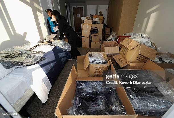 Volunteer Lois Carrefoot and summer Olympian Robyn Wong of New Zealand gather the New Zealand athlete's bags in the uniform room ahead of the...