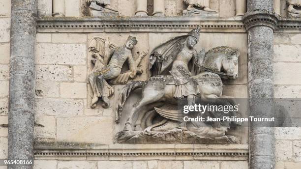 sculpture of st. george slaying the dragon on the facade of angouleme cathedral, france - moleculas stockfoto's en -beelden