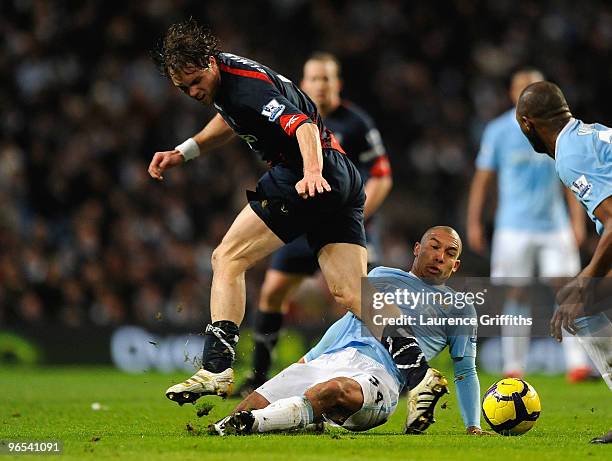 Johan Elmander of Bolton Wanderers is challenged by Nigel de Jong of Manchester City during the Barclays Premier League match between Manchester City...