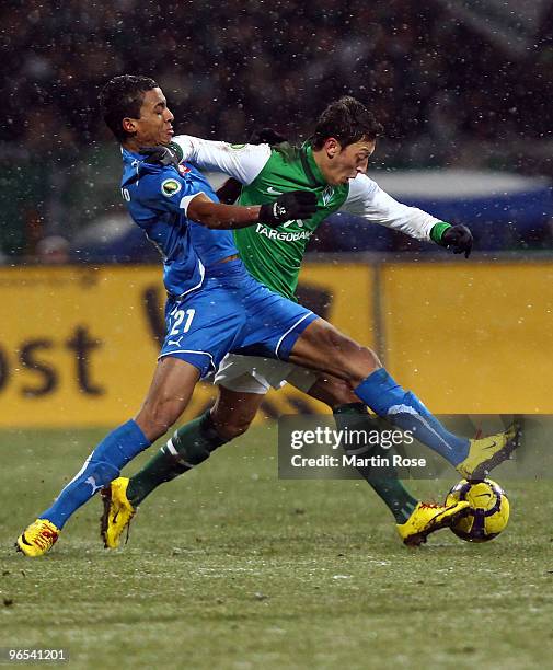 Mesut Oezil of Bremen and Luiz Gustavo of Hoffenheim battle for the ball during the DFB Cup quarter final match between SV Werder Bremen and 1899...