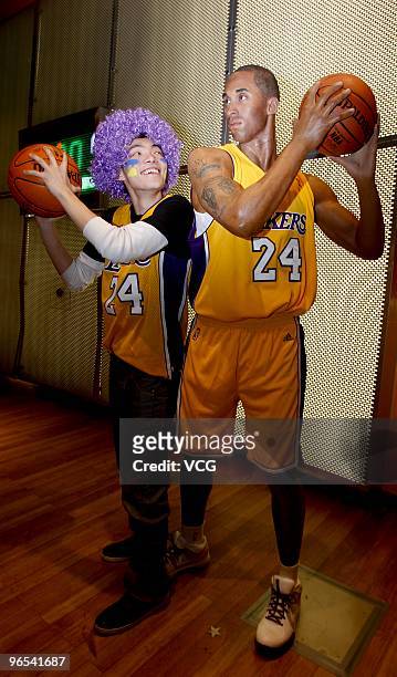 Lakers fan poses for photos with the waxwork of American shooting guard Kobe Bryant at Madame Tussauds on February 9, 2010 in Shanghai of China.