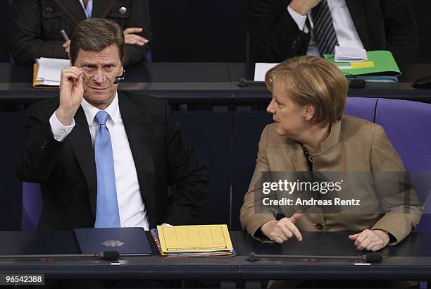 German Vice Chancellor and Foreign Minister Guido Westerwelle and German Chancellor Angela Merkel gesture during a session at the German Parliament...