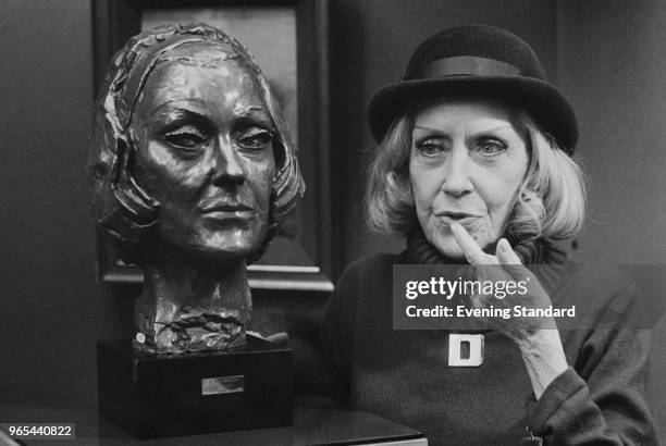 American actress Gloria Swanson poses with self-portrait sculpture, UK, 30th January 1979.