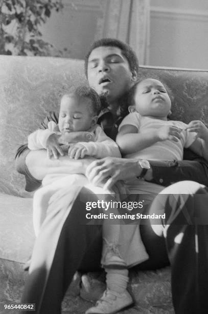 American heavyweight boxer Muhammad Ali takes a nap while babysitting two of his daughters by wife Veronica Porche, 9 month old Laila and 2 year old...