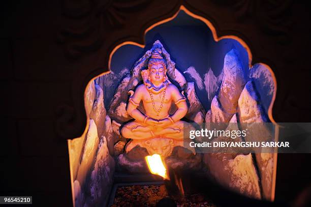 An Indian Hindu priest performs puja - prayers - inside a Lord Shiva temple in Bangalore on February 10, 2010. A portion of the temple complex has...