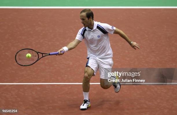 Olivier Rochus of Belgium plays a volley in his match against Gael Monfils of France during day three of the ABN AMBRO World Tennis Tournament on...