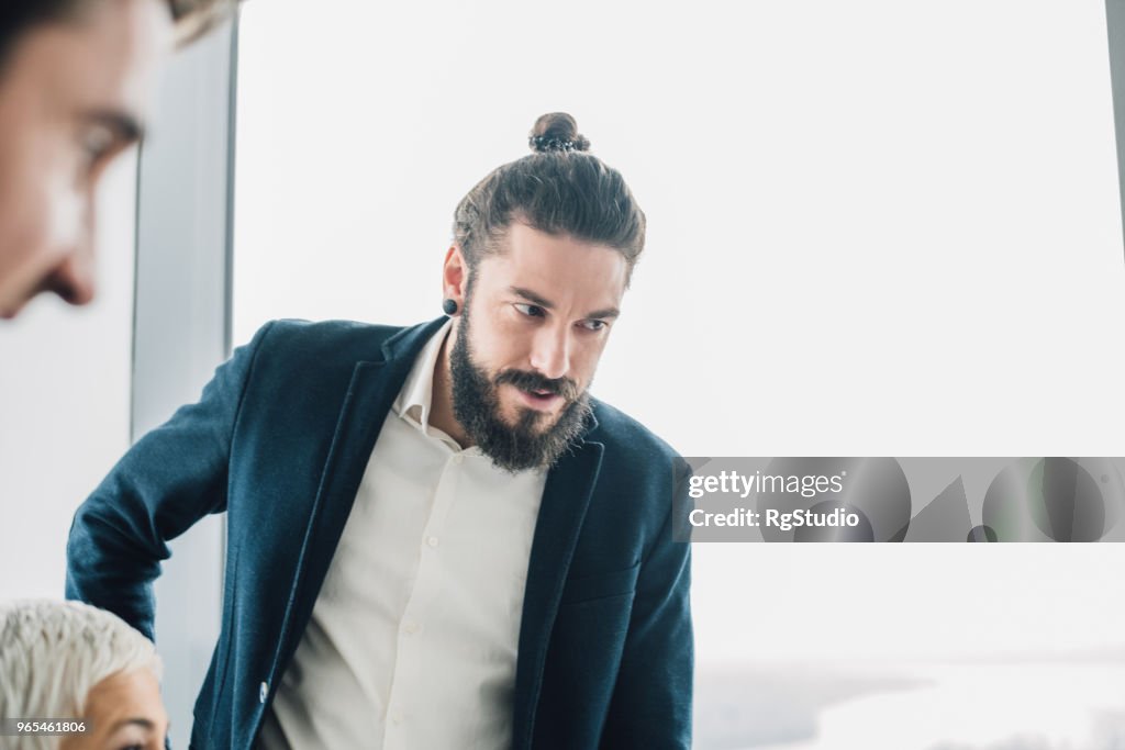 オフィスで同僚と青年実業家