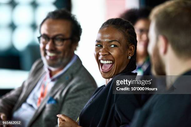 businesspeople laughing at conference - business relationship stock pictures, royalty-free photos & images