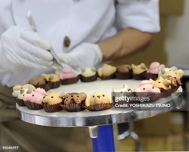 Japan's sweet shop Goncharoff chocolatier puts the finishing touches to animal-shaped chocolates at Takashimaya department store's Valentine's Day...