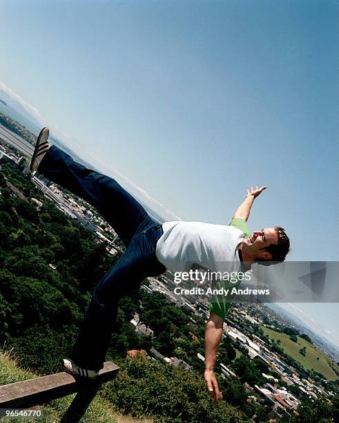 young man trying to balance on wooden rail fencing - andy andrews stock-fotos und bilder