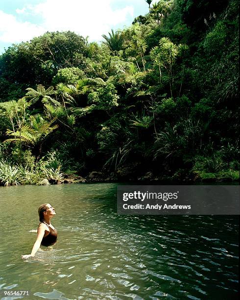 young woman in lagoon enjoying the sun - andy andrews stockfoto's en -beelden