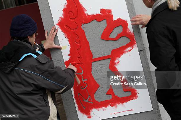 Workers paint the Berlinale bear logo on an outdoor column ahead of the 60th Berlinale International Film Festival on February 10, 2010 in Berlin,...