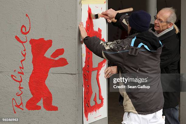 Workers paint the Berlinale bear logo on an outdoor column ahead of the 60th Berlinale International Film Festival on February 10, 2010 in Berlin,...