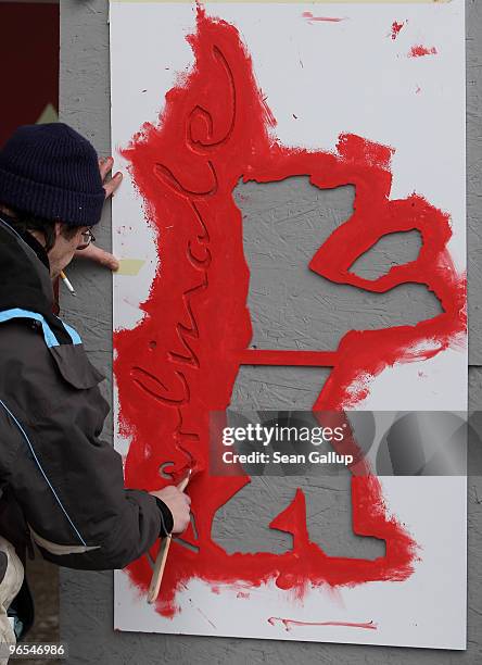 Worker paints the Berlinale bear logo on an outdoor column ahead of the 60th Berlinale International Film Festival on February 10, 2010 in Berlin,...