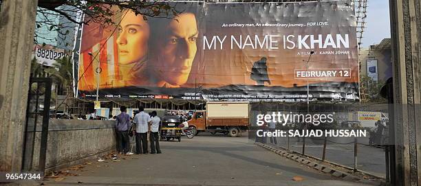 Pedestrians look at a huge poster advertising the controversial Indian movie 'My Name is Khan' featuring film actor Shah Rukh Khan in Mumbai on...