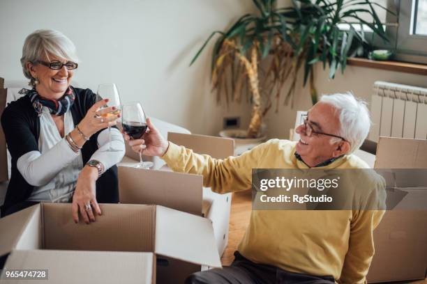 happy elderly couple moving to new apartment - senior moving house stock pictures, royalty-free photos & images