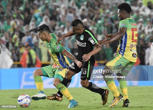Ronaldo Tavera and Elvis Perlaza of Huila fight for the ball with Vladimir Hernandez of Nacional during semifinal first leg match between Atletico...