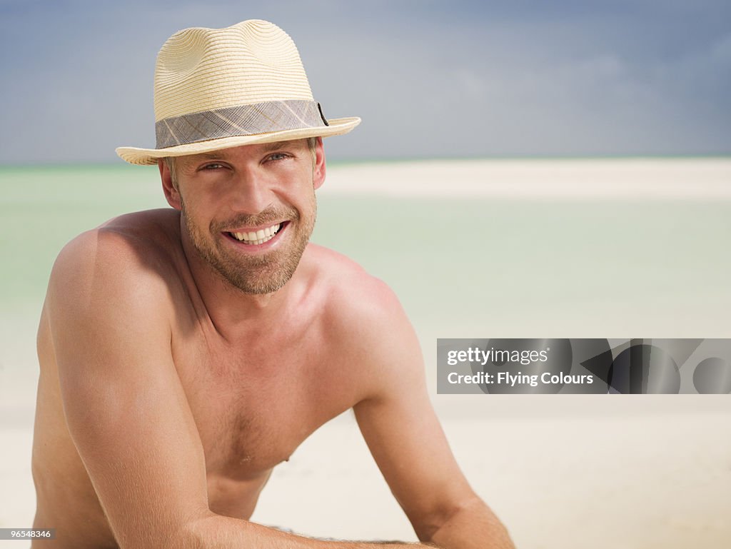 Portrait of man in hat on beach
