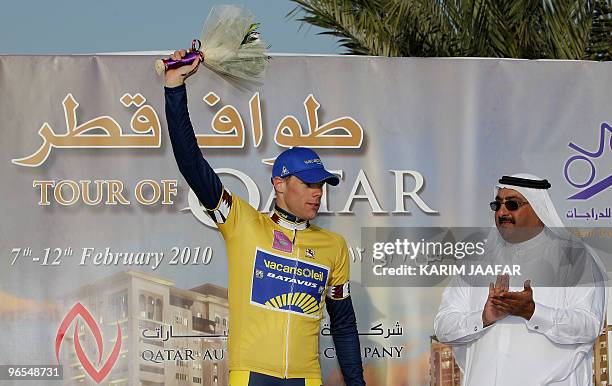 Qatar's cycling federation president, Sheikh Khaled bin Ali al-Thani, applaudes as Vacansoleil team rider Wouter Mol of the Netherlands celebrates in...